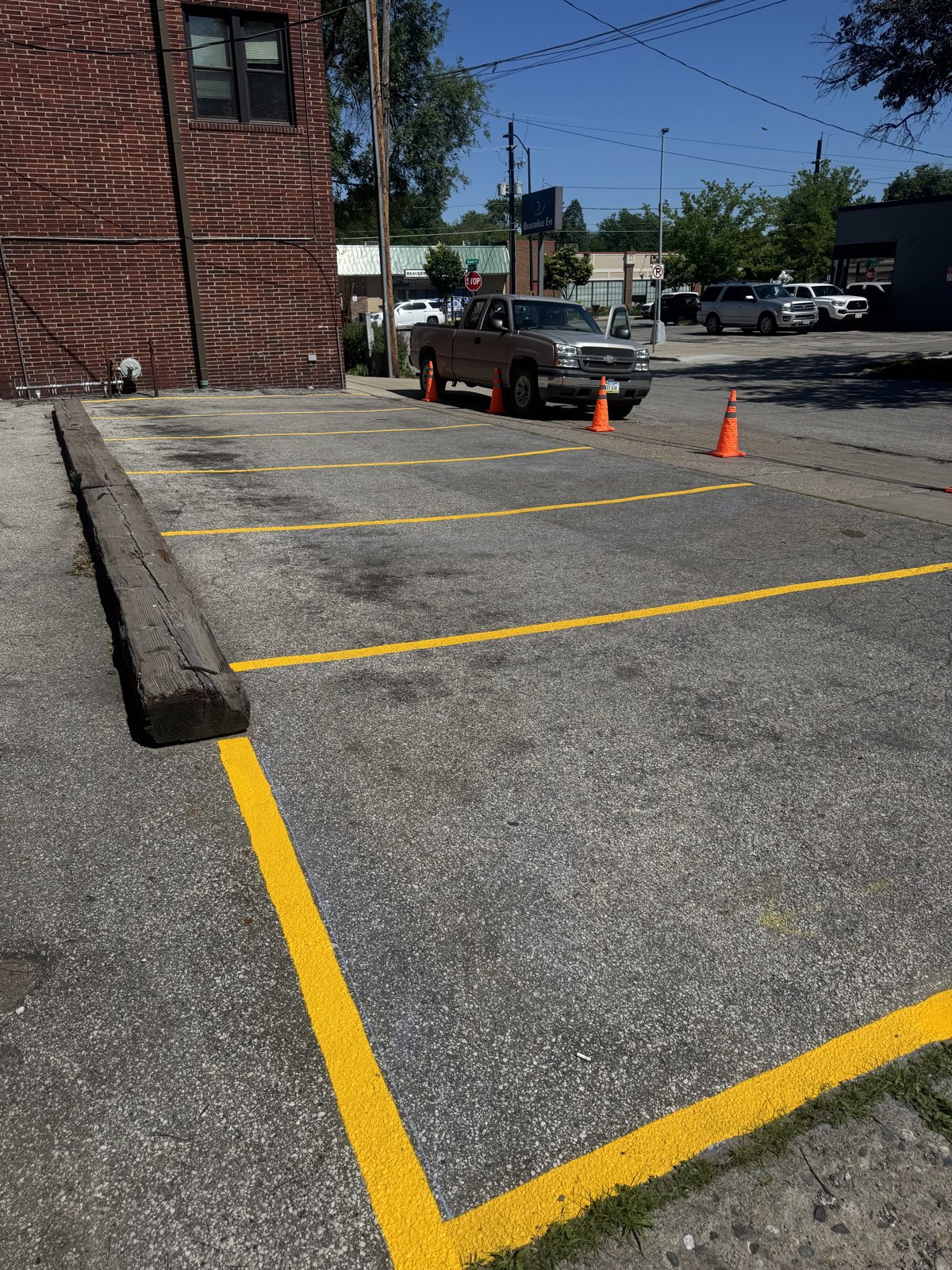 Fresh bright yellow parking stall lines on a newly laid-out commercial lot in Iowa